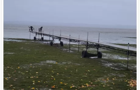 Wind-driven low water in Fond du Lac showing dock exposed on grass during storm event