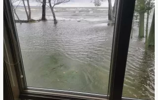Flooded yard and shoreline in Menasha seen through window during wind surge on Lake Winnebago