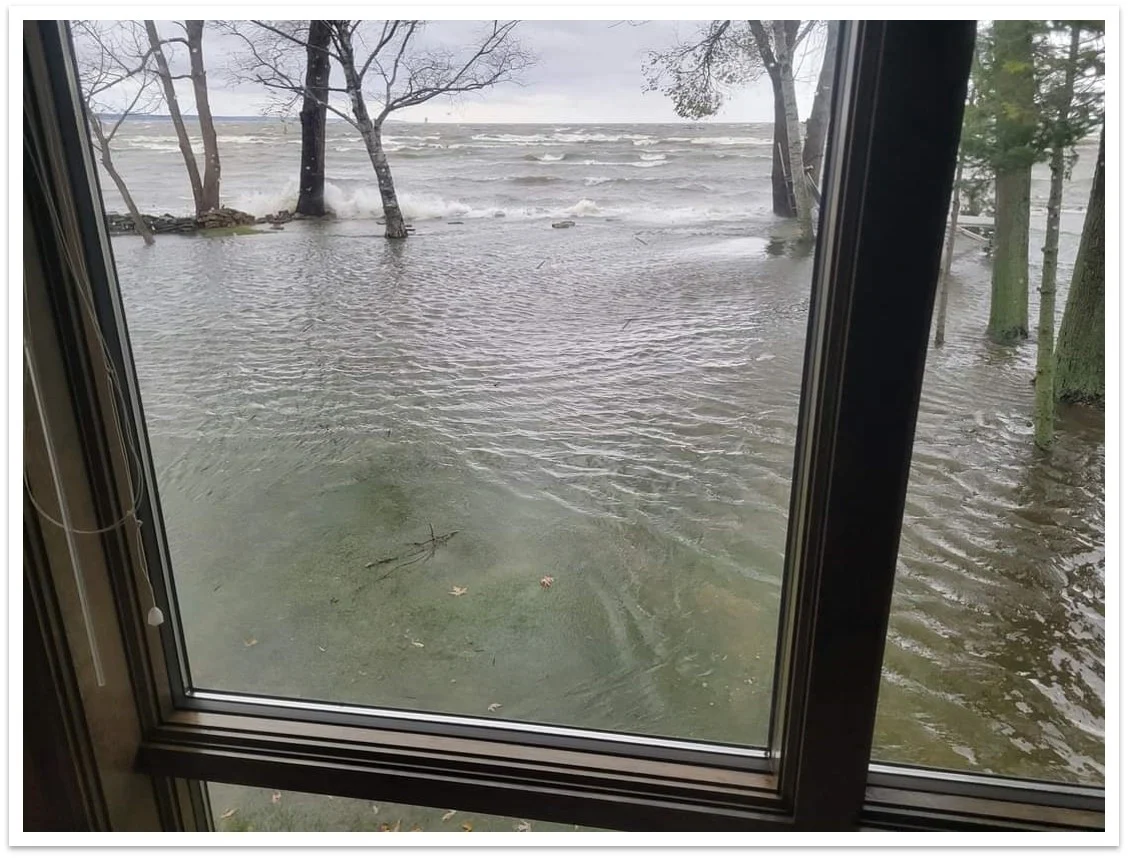 Flooded yard and shoreline in Menasha seen through window during wind surge on Lake Winnebago