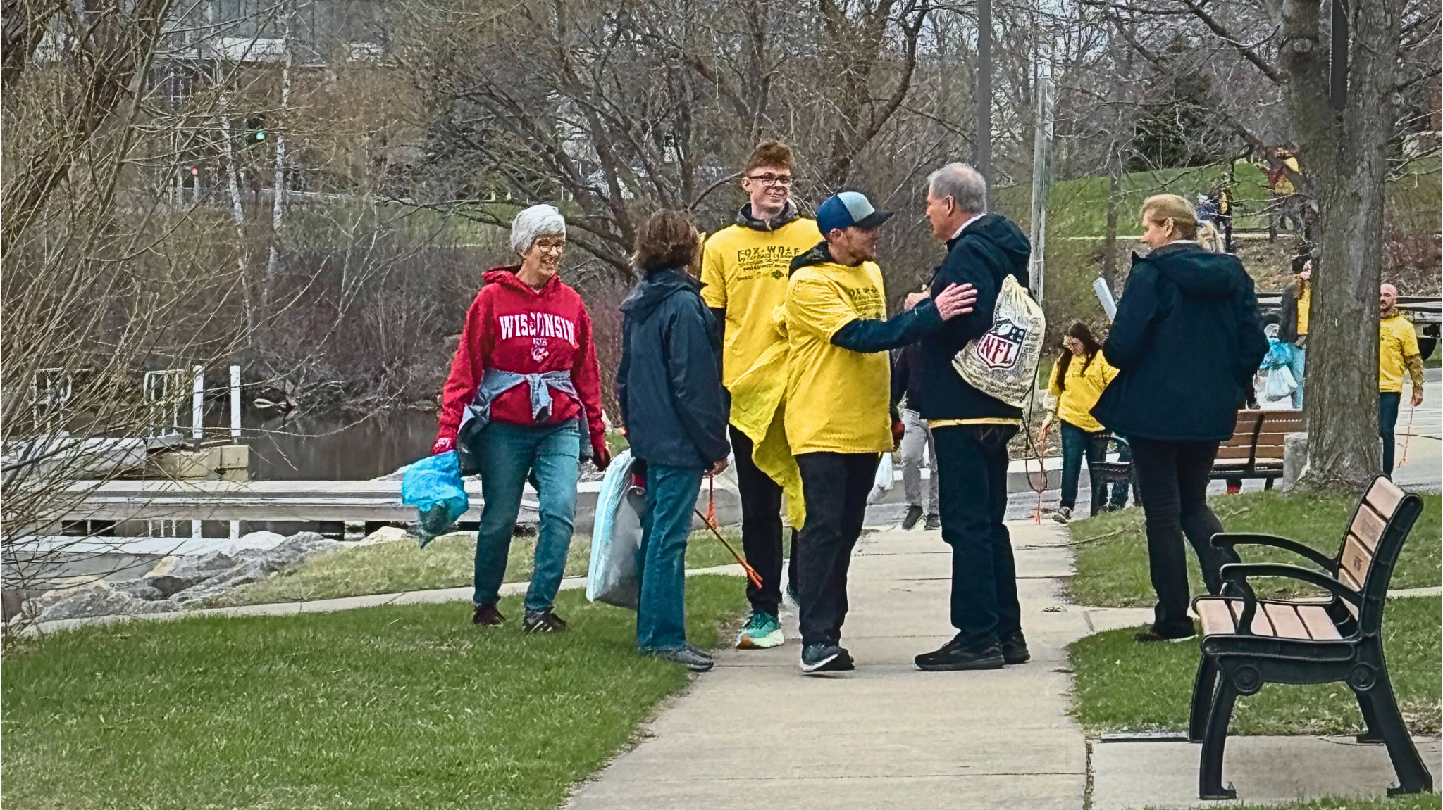 Jack and Susan Groh greets volunteers wearing yellow cleanup shirts during the 2025 Earth Day event along the Fox River Trail in Green Bay.